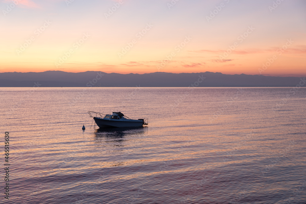 loney motorboat at Kvarner Bucht ocean, mountain view at sunrise, croatia
