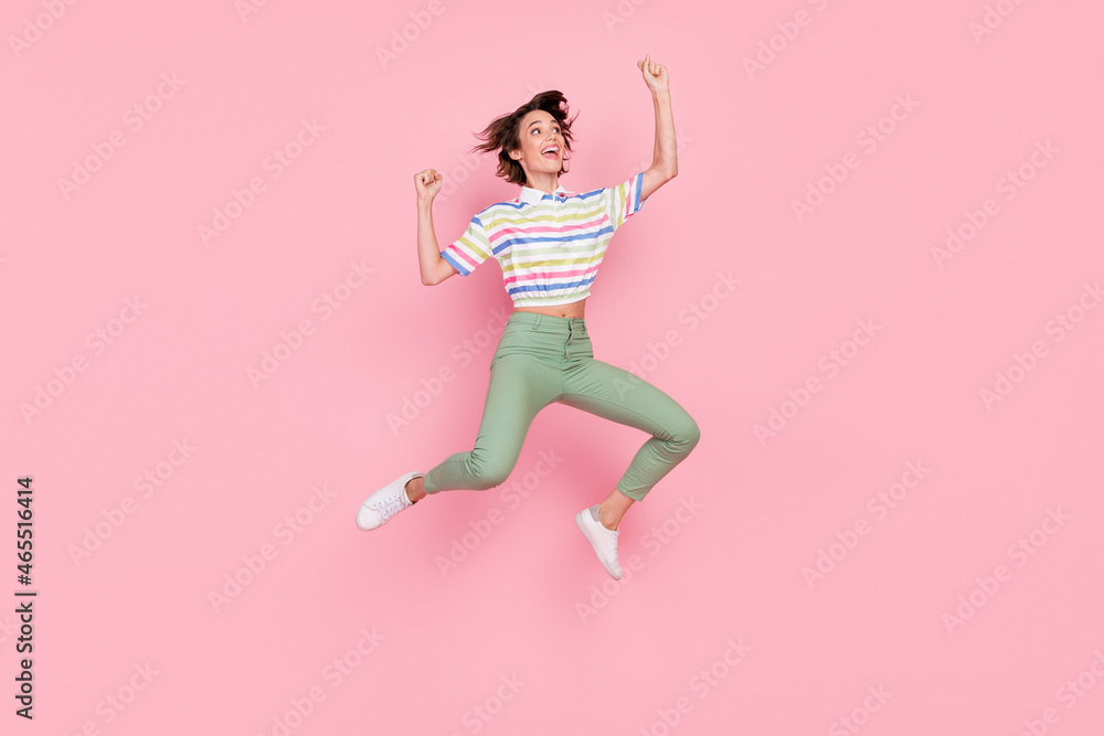 Full length profile side photo of young girl happy positive smile celebrate victory jumper isolated over pink color background