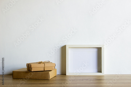 A white photo frame with boxes on table with nature light.