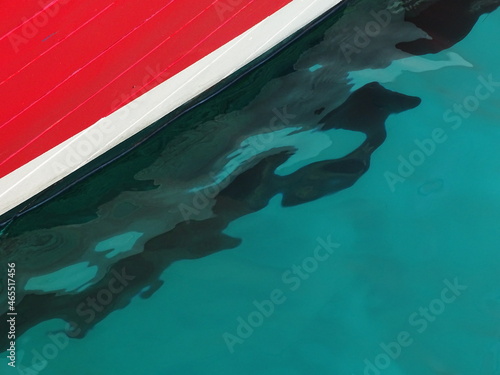 Wellenförmiger Schattenwurf vom Rumpf eines Fischerbootes in der glasklaren Adria