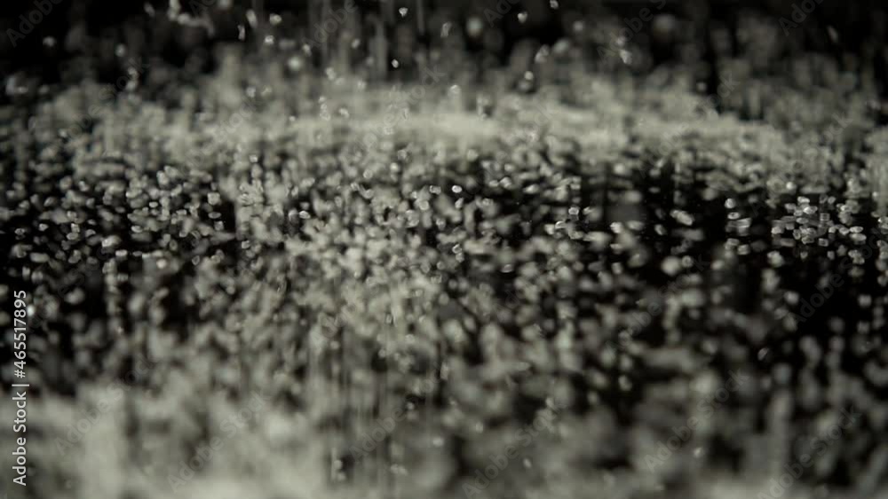 Falling grains of sugar on a black mirror background. Slow motion. Falling grains of sugar on a black mirror background. Slow motion.