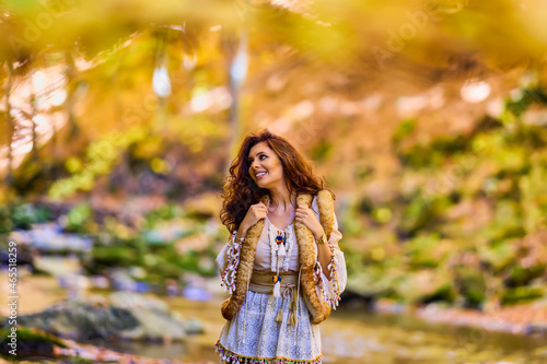 Autumn portrait with a beautiful woman in different positions near a mountain river.