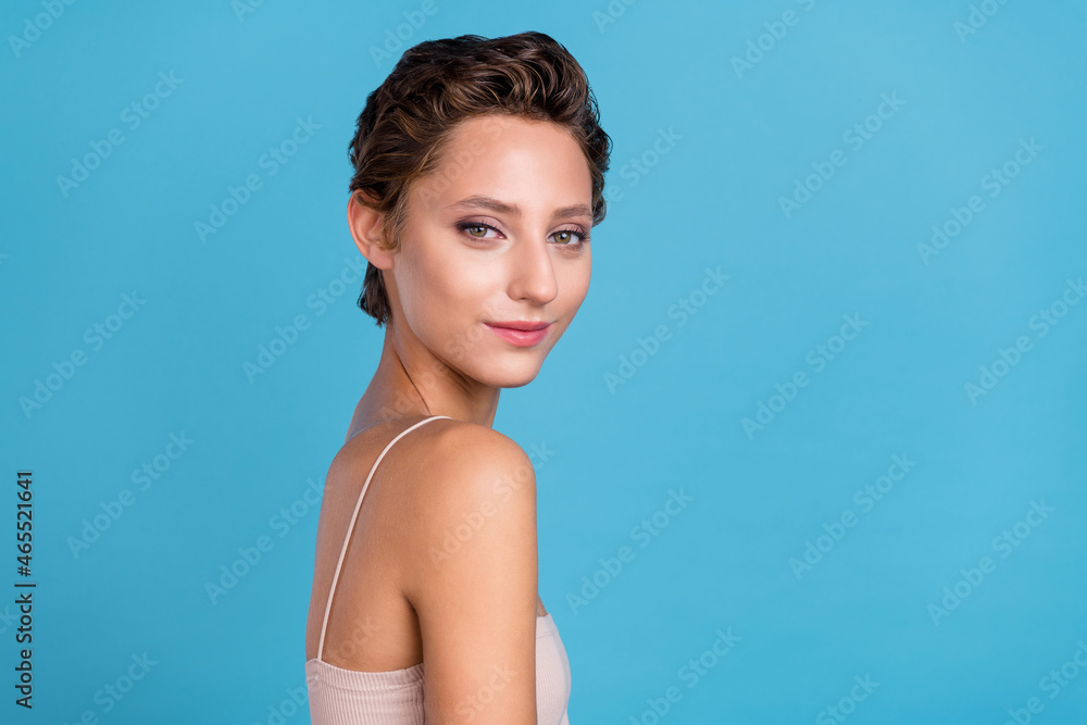 Photo of adorable shiny young lady wear beige top smiling isolated blue color background Photo of adorable shiny young lady wear beige top smiling isolated blue color background