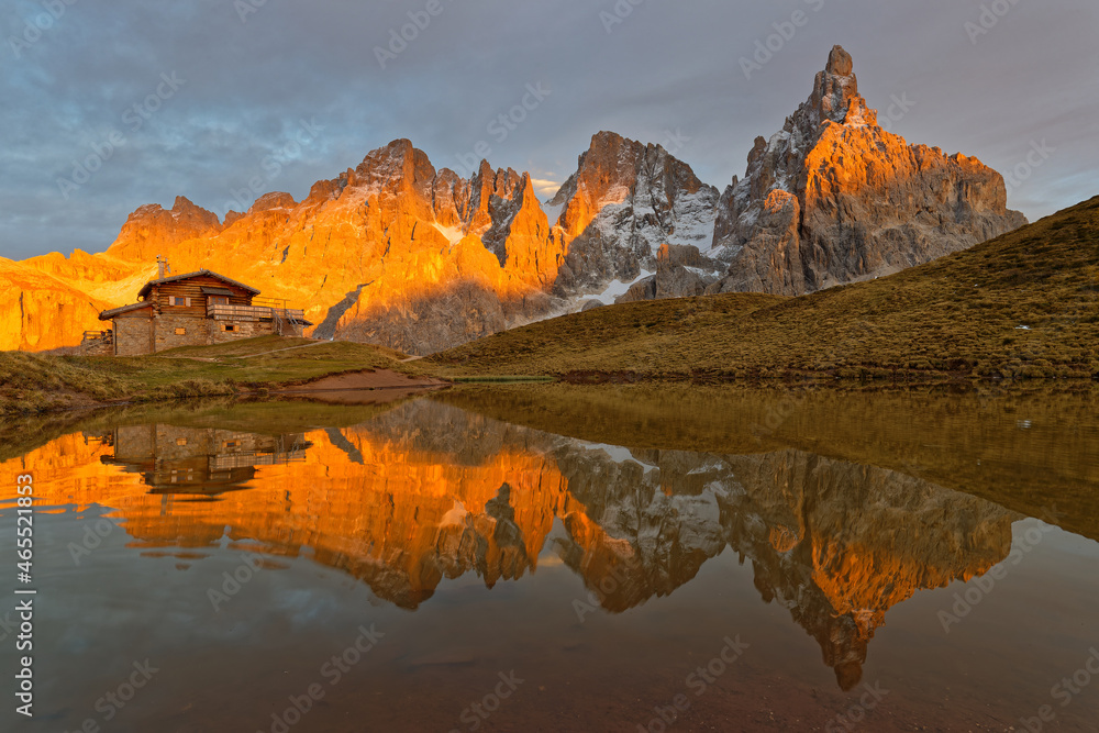 PASSO ROLLE, ITALY, October 19, 2021 : Pale di San Martino Group reflecting on a lake during sunset, in Dolomites mountains.