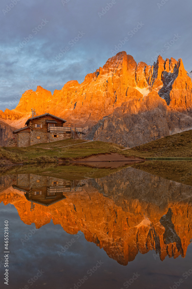 PASSO ROLLE, ITALY, October 19, 2021 : Pale di San Martino Group reflecting on a lake during sunset, in Dolomites mountains.