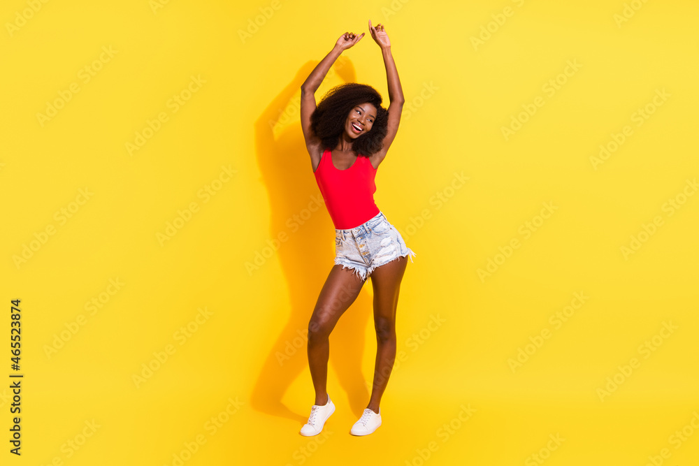 Full length body size view of attractive cheerful girl dancing having fun isolated over bright yellow color background Full length body size view of attractive cheerful girl dancing having fun isolated over bright yellow color background