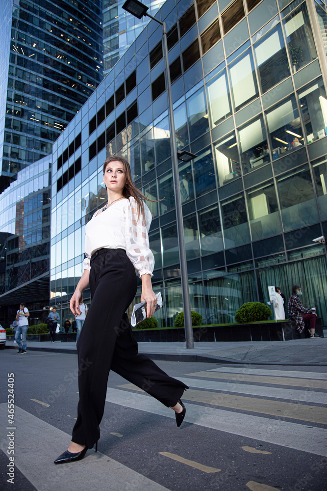 Walking young business woman on the street of a modern city Walking young business woman on the street of a modern city