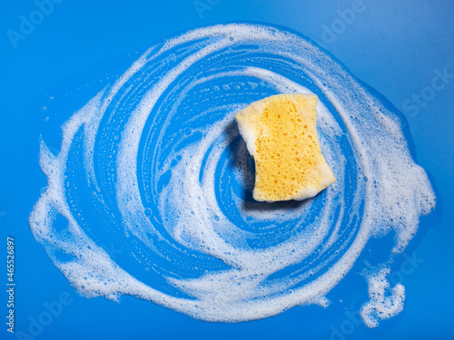 Fotografía cleaning sponge wiping foam soap suds on blue background, household washing conc