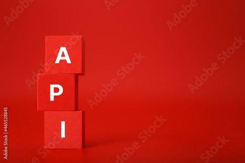 Obraz na płótnie API concept in monochromatic red colors with copy space. API written on stack of red toy cubes w salonie