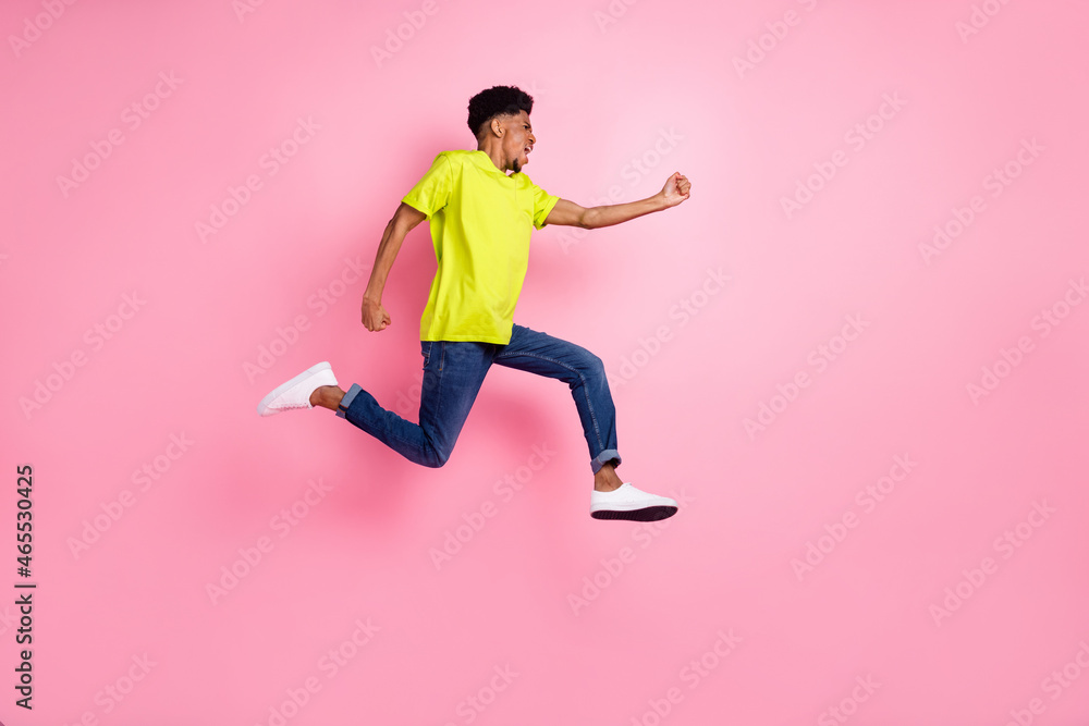 Full length body size profile side view of nice purposeful guy jumping running active isolated over pink pastel color background