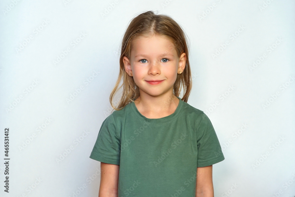 © Vladimir - Portrait of a girl on a white background. Collected hair and green T-shirt. Cute smile happy smile. A cheerful and serious child looks at the camera. place for text. © Vladimir - Portrait of a girl on a white background. Collected hair and green T-shirt. Cute smile happy smile. A cheerful and serious child looks at the camera. place for text.