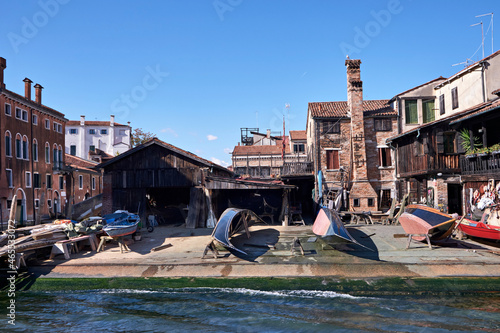 Venice, panoramic image of empty Squero di San Trovaso boatyard in Venice. Landmark boat yard building traditional wooden gondolas. Several boats are waiting to be fixed, repaired on the shore. photo