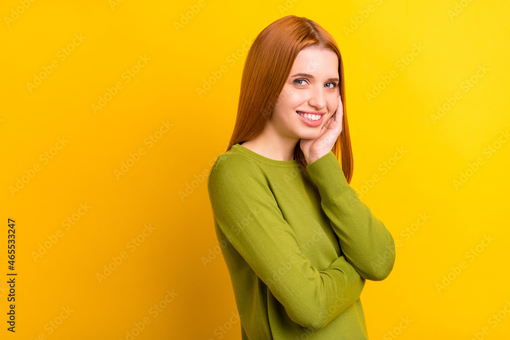 Photo portrait red haired woman in green sweater smiling touching cheek isolated vivid yellow color background copyspace Photo portrait red haired woman in green sweater smiling touching cheek isolated vivid yellow color background copyspace