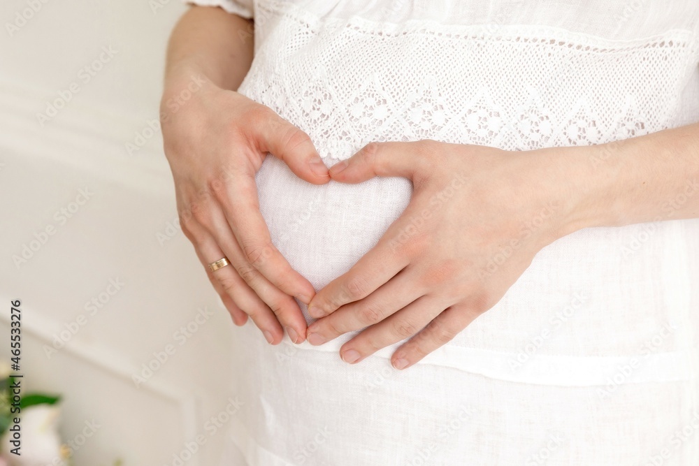 pregnant girl folded her hands on her stomach in the shape of a heart pregnant girl folded her hands on her stomach in the shape of a heart