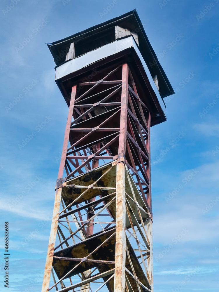 Abandoned observation tower on a sunny spring day on a background of sky and clouds. Abandoned observation tower on a sunny spring day on a background of sky and clouds.
