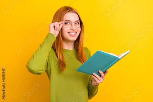 Photo portrait red haired woman in glasses reading book preparing for test isolated vivid yellow color background