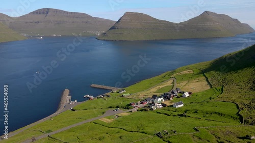 Beautiful cinematic aerial footage of the small ferry pier and town if Sydradalur in Kalsoy, on the Faroe Islands
