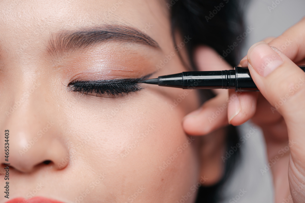 young woman applied eyeliner close-up