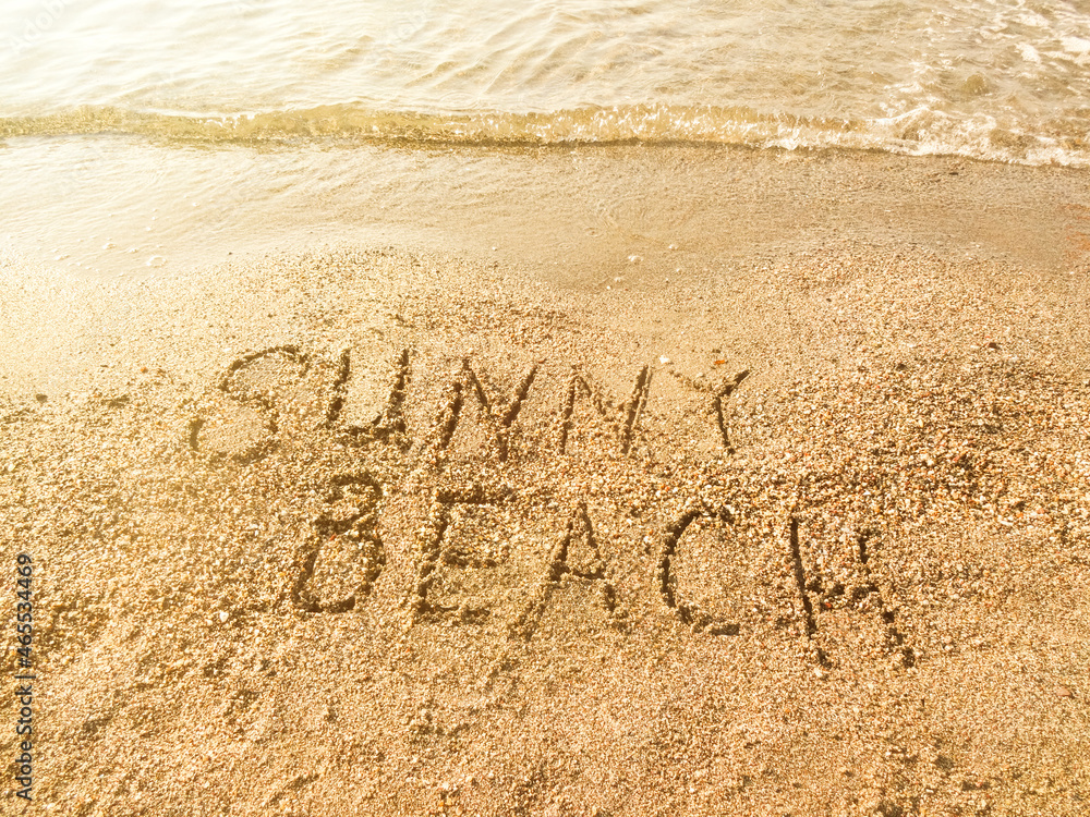 Fototapeta premium The inscription Sunny beach on the sea sand