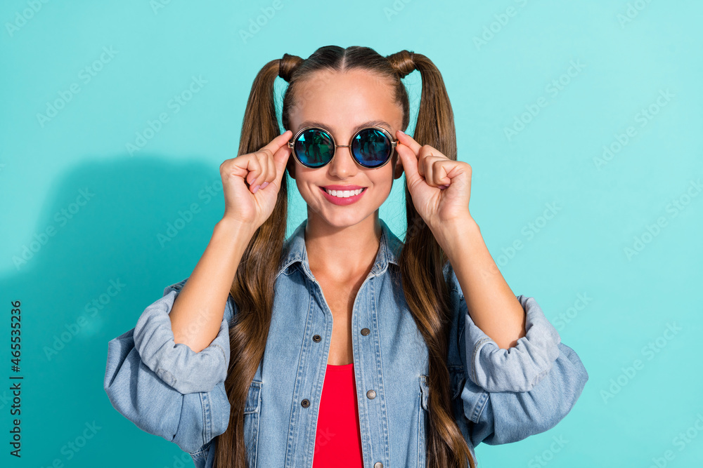 Photo of pretty charming young lady wear jeans shirt smiling arms dark eyewear isolated turquoise color background Photo of pretty charming young lady wear jeans shirt smiling arms dark eyewear isolated turquoise color background