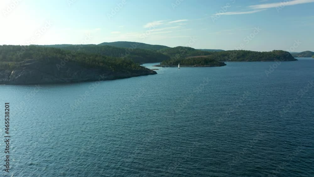 Aerial view flying over water toward rocky coastline Aerial view flying over water toward rocky coastline