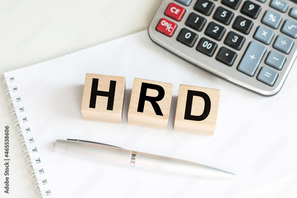 text of HRD on the wooden cubes on the table on a notebook next to a calculator and a pen text of HRD on the wooden cubes on the table on a notebook next to a calculator and a pen