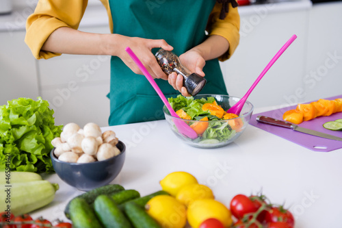 Photo of adorable pretty dark skin woman dressed yellow shirt cooking flavoring salad indoors house home room