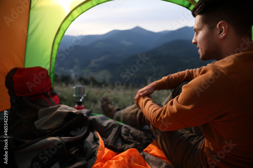 Man inside of camping tent in mountains