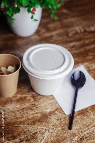 Close-up of soup in a glass. Takeaway food in disposable dishes. A paper cup with a hodgepodge, mushroom soup and croutons. The concept of fast food in a cafe.