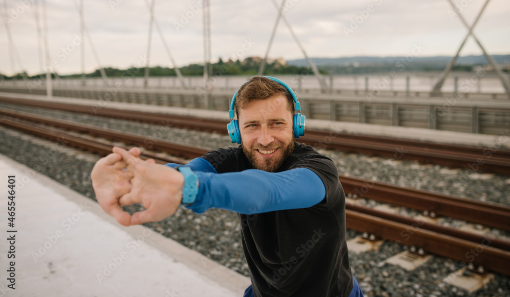 Obraz premium a smiling athlete in the afternoon training for exercise and listening to music
