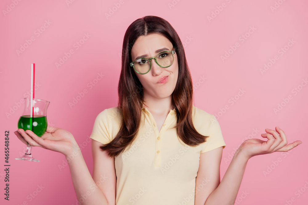 Photo of doubted uncertain lady hold cocktail shrug shoulders clueless mood on pink background Photo of doubted uncertain lady hold cocktail shrug shoulders clueless mood on pink background