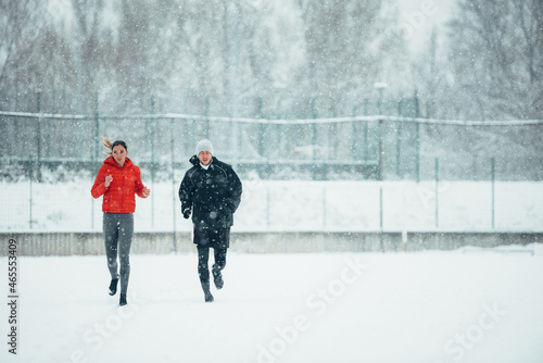 Young couple going for a run together during a snow