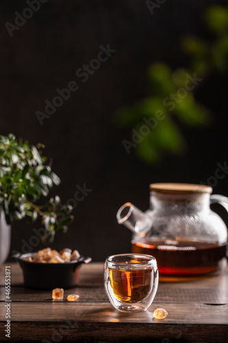 Black hot tea with sugar lollipops on a wooden table