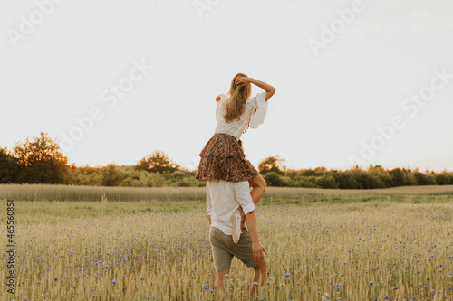 The spirit of travel  freedom and independence. Happy young couple in love running in the field in the sunset light. Messy hair. Freedom and love concept. Close up of holding hands.  
