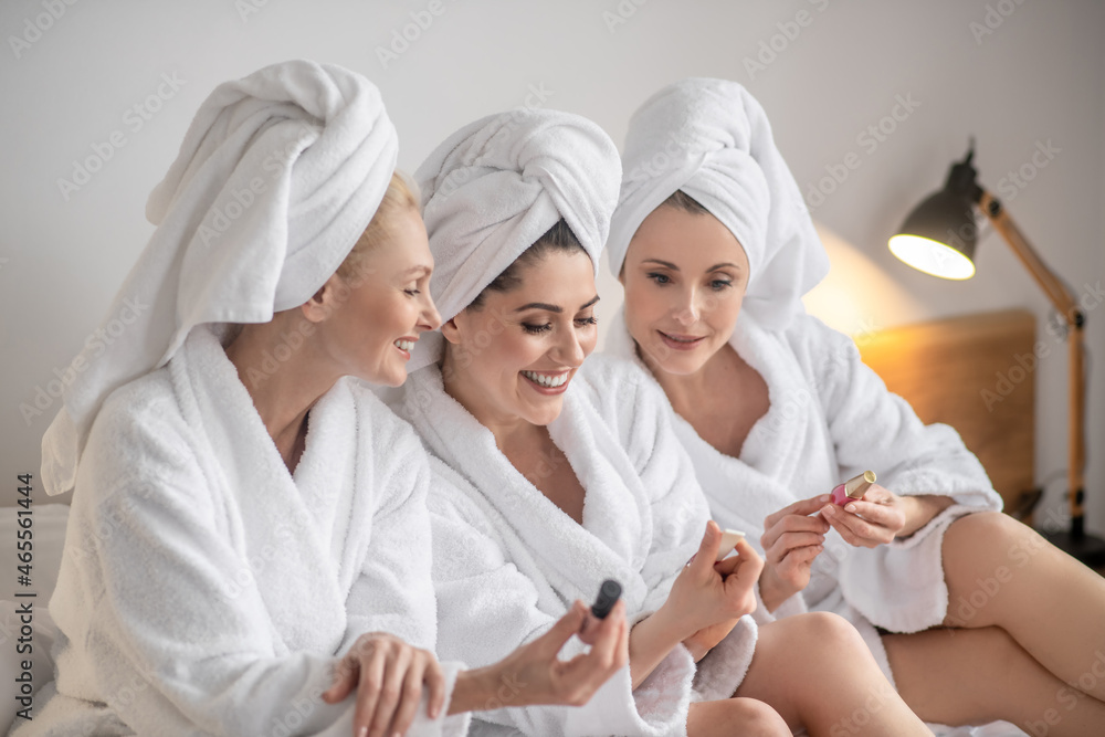 Three lovely women in cosmetics in hands Three lovely women in cosmetics in hands
