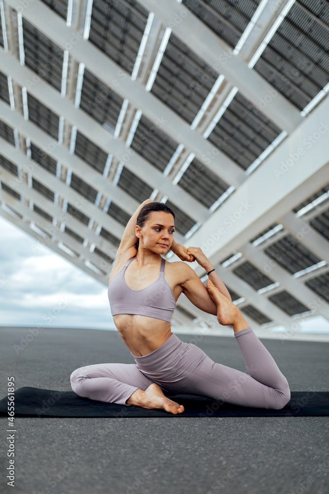 Sportive woman practicing mermaid posture on street Sportive woman practicing mermaid posture on street