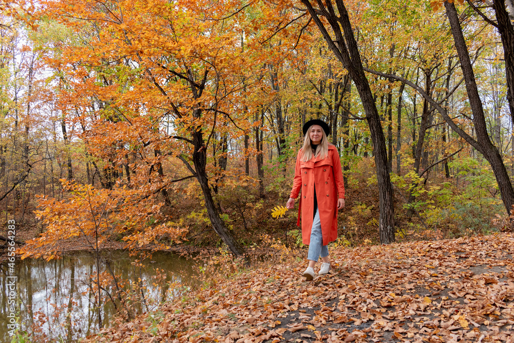 Young girl with blond hair walks in the autumn forest. Wellness concept. Young girl with blond hair walks in the autumn forest. Wellness concept.