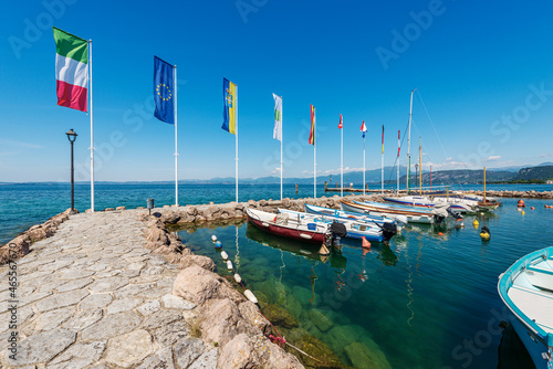 Lake Garda (Lago di Garda), small port with many boats moored. Cisano village, tourist resort in Verona province, Bardolino municipality, Veneto, Italy, Europe. On horizon the coast of the Lombardy. photo