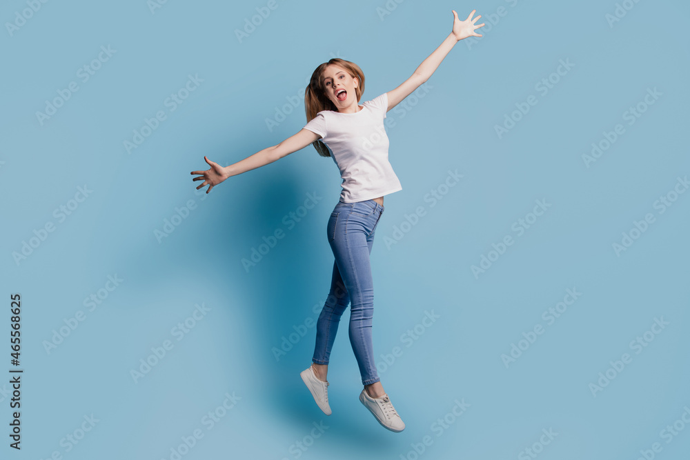 Photo of positive cheerful inspired crazy funky lady fly enjoy jump wear casual clothes on blue color background