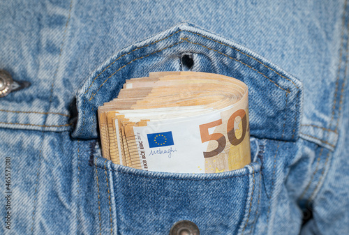 A bundle of 50 euro banknotes in pocket of a denim jacket photo