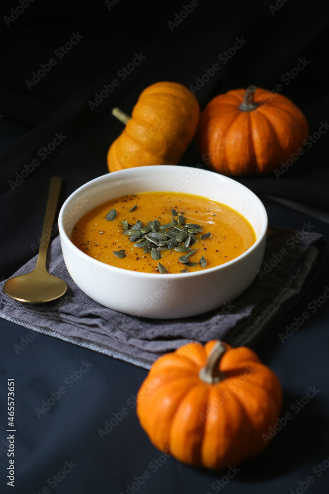 A bowl of pumpkin soup with seed in a black background with small ack-Be-Little squash. An ideal for diet people and vegetarian with highly nutrient and health benefits. A bowl of pumpkin soup with seed in a black background with small ack-Be-Little squash. An ideal for diet people and vegetarian with highly nutrient and health benefits.
