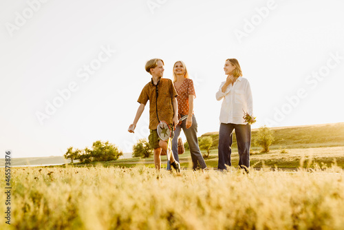 White family smiling together while walking on summer field