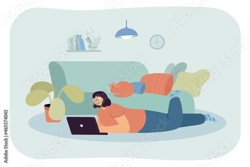 Happy cartoon woman lying on floor with laptop and cat on sofa. Girl working from home flat vector illustration. Remote work, freelancing, relaxation concept for banner, website design or landing page