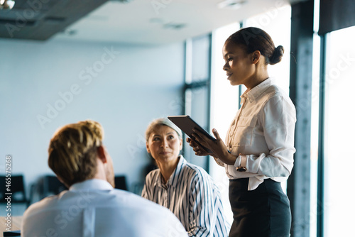 Multiracial man and women discussing project during meeting in office