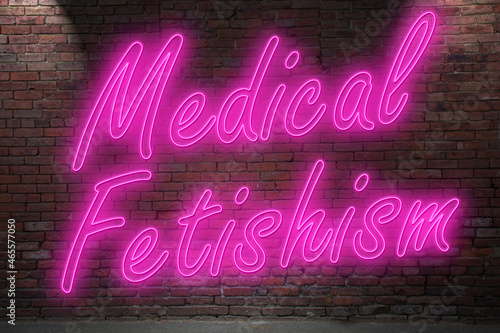 Neon medical fetishism (in german Klinikerotik) lettering on Brick Wall at night