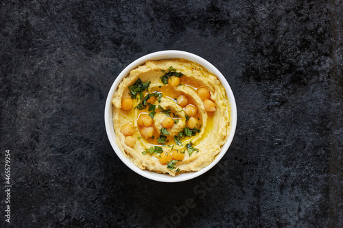 Hummus - chickpea traditional jewish and lebanese cuisine meal on black background, flat lay, from above overhead top view, closeup, houmous is a vegan healthy legume food