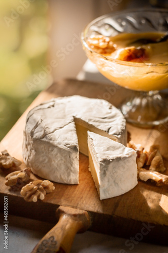 Brie cheese or camembert on cheese platter with walnuts. Closeup view, selective focus