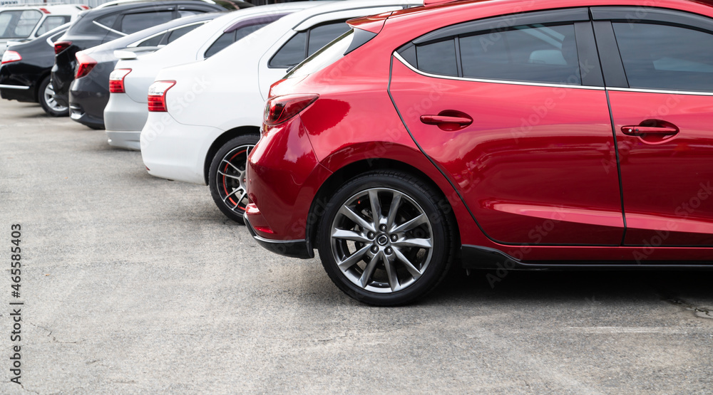 Red car parked neatly inside an outdoor parking lot with copy space.