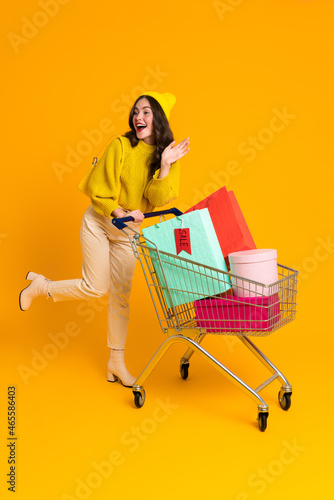 White excited woman gesturing while posing with shopping cart © Drobot Dean