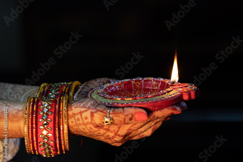 Beautiful Woman lady hand with bangles holding Handcrafted Eco Friendly Clay Diya Deep Dia Glowing lamps for Hindu festival Laxmi poojan (Diwali)